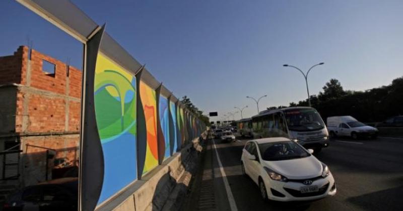 Πολύχρωμος "Ολυμπιακός" φράχτης κατά μήκος του δρόμου από το αεροδρόμιο προς τα γήπεδα, για να μη μολύνεται το βλέμμα των επισκεπτών από τις φαβέλες