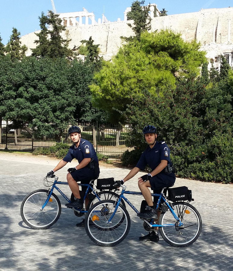 (Ξένη δημοσίευση). Φωτογραφία που δόθηκε σήμερα στη δημοσιότητα και εικονίζει αστυνομικούς με τα ποδήλατά τους στο κέντρο της Αθήνας. Πιλοτικό πρόγραμμα περιπολιών αστυνόμευσης, με χρήση ηλεκτροκίνητων ποδηλάτων, θέτει σε εφαρμογή το Αρχηγείο της Ελληνικής Αστυνομίας, στο πλαίσιο της νέας αντεγκληματικής πολιτικής και με σκοπό την αναβάθμιση της προστασίας και της εξυπηρέτησης, τόσο των πολιτών όσο και των επισκεπτών της χώρας. Το πρόγραμμα ξεκίνησε πρόσφατα στην Αθήνα, στην ευρύτερη περιοχή του αρχαιολογικού χώρου της Ακρόπολης, ενώ στη Θεσσαλονίκη εφαρμόζεται ήδη από τις 4 Σεπτεμβρίου 2015, ημέρα των εγκαινίων της 80ης Διεθνούς Έκθεσης. Η αστυνόμευση με χρήση ποδηλάτων αναμένεται να επεκταθεί και σε άλλες πόλεις όπως στην Κέρκυρα, τη Ρόδο, τα Χανιά και το Ναύπλιο. Κυριακή 04 Οκτωβρίου 2015. ΑΠΕ-ΜΠΕ/ΥΠΟΥΡΓΕΙΟ  ΠΡΟΣΤΑΣΙΑΣ ΤΟΥ ΠΟΛΙΤΗ/STR