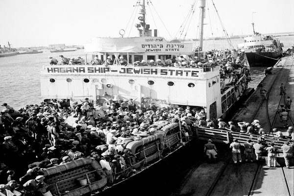 The ship "The Jewish State" docking at the cargo jetty at Haifa Port  on October 3, 1947. This ship is also called "Medinat Yehudim."   Soldiers of the Airborne Division are boarding the ship.    In the background is the ship "Geulah" or Redemption which brought another 1500 illegal immigrants a few hours earlier on this day. Palestine under British rule was limiting the number of Jewish immigrants.  As part of a rescue operation, the Palestine Jewish underground was transporting Holocaust survivors and Jewish settlers to the area and this was called "illegal immigration."   (AP Photo)
