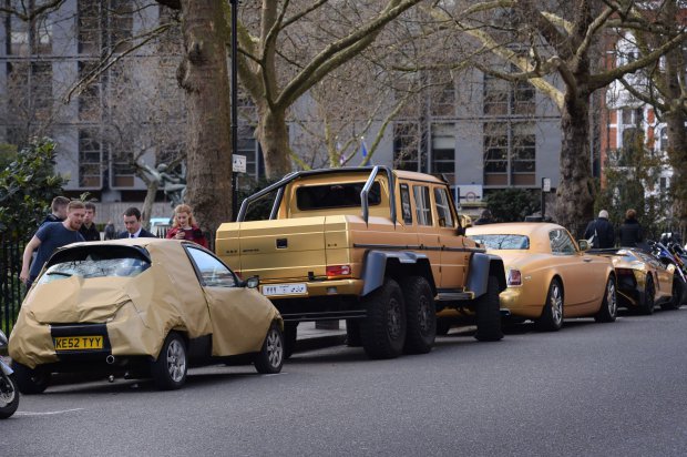 A Ford Ka covered in gold wrapping paper is parked next to three gold cars from Saudi Arabia (second left-right) a 6x6 Mercedes G 63, Rolls-Royce Phantom Coupe and Lamborghini Aventador on Cadogan Place in Knightsbridge, London, as all three gold cars have received a parking ticket. PRESS ASSOCIATION Photo. Picture date: Wednesday March 30, 2016. See PA story TRANSPORT Knightsbridge. Photo credit should read: Stefan Rousseau/PA Wire