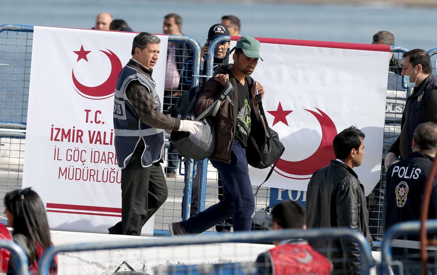 epa05243103 Migrants are escorted by Turkish police as they arrive by ferry from the Greek island of Lesvos (Lesbos) at the Dikili harbour in Izmir, Turkey, 04 April 2016. Some 160 migrants, from Pakistan, Bangladesh and Morroco, who refused to apply for asylum, have been deported on 04 April early morning to Turkey, after an agreement between the European Union (EU) and Turkey on the refugees crisis. EPA/TOLGA BOZOGLU