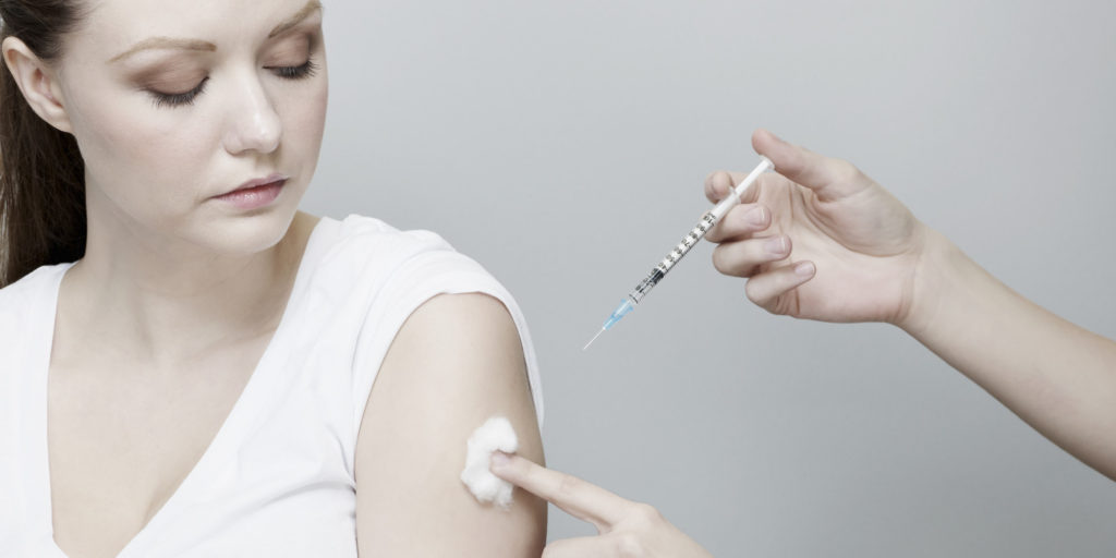 Woman Receiving Vaccination in Arm.
