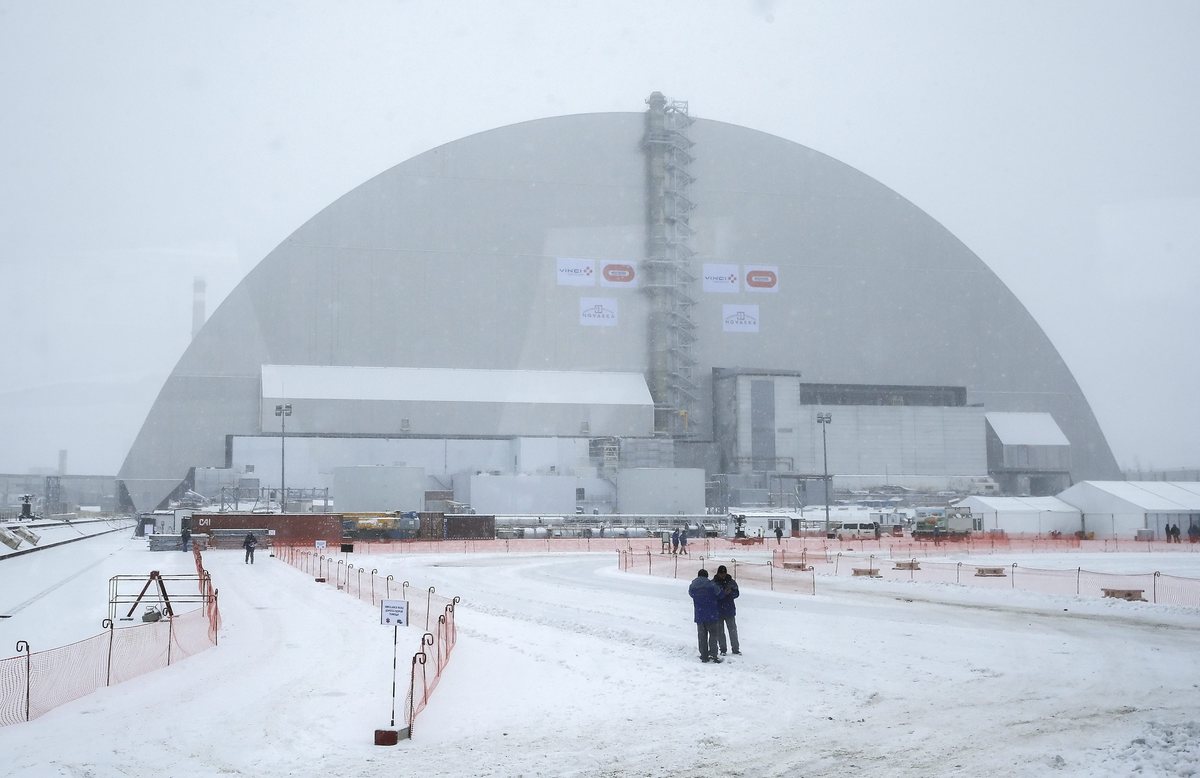 epa05651755 Picture shot through a bus window shows a general view of the new protective shelter which placed over the remains of the nuclear reactor Unit 4, at Chernobyl nuclear power plant, in Chernobyl, Ukraine, 29 November 2016. The explosion of Unit 4 of the Chernobyl nuclear power plant in the early hours of 26 April 1986 is still regarded the biggest accident in the history of nuclear power generation. Under extremely hazardous conditions a steel and concrete structure was built hastily immediately after the accident. The new concrete and steel built over the still-radioactive remains of a reactor which was melted down as a result of the accident and has 105 meters tall, 150 meters length with a width of 257 meters and a 100 years life expectancy of the confinement.  EPA/SERGEY DOLZHENKO