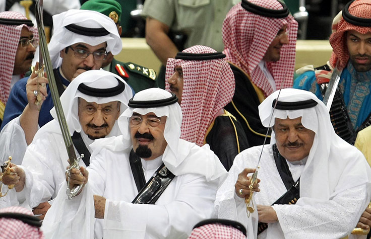 FILE - In this Tuesday, March 23, 2010 file photo, King Abdullah, center, of Saudi Arabia and his half brother Saudi Interior Minister Prince Nayef bin Abdul Aziz al-Saud, right, hold their swords as they take part in the traditional Arda dance, or War dance, during the Janadriyah Festival of Heritage and Culture on the outskirts of Riyadh, Saudi Arabia. King Abdullah has ratified a new counter-terrorism law which went into effect Sunday, Feb. 2, 2014. Rights activists said that the law criminalizes speech critical of the government or society. It was published in full in the government's official gazette Um Al-Qura Friday. (AP Photo, File)